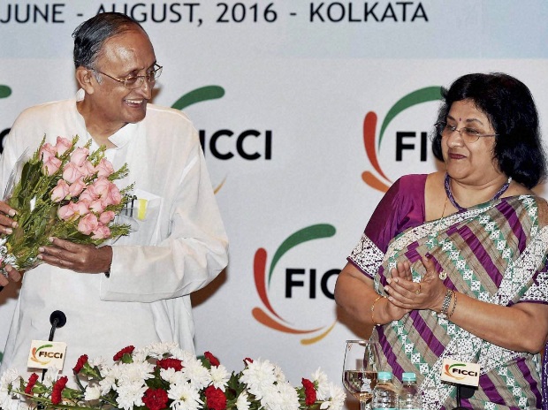 West Bengal Finance Minister Amit Mitra receives a bouquet from Chairman, FICCI's West Bengal State Council, Gaurav Swarup as Chairperson, State Bank of India, Arundhati Bhattacharya looks on during 13th Banking Conclave in Kolkata