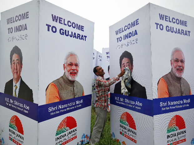 A worker cleans a hoarding featuring India's Prime Minister Narendra Modi and his Japanese counterpart Shinzo Abe ahead of Abe's visit in Ahmedabad. (Photo: Reuters)
