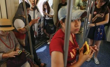 Condoms have left Bangkok lenders with no option but to go overseas Passengers use their mobile phones on a skytrain in Bangkok