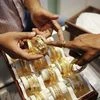 An employee shows gold bangles to a customer at a jewellery showroom on the occasion of Dhanteras, a Hindu festival associated with Lakshmi, the goddess of wealth, at a market in Mumbai.