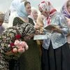 A woman bows during a religious service by villagers in memory of the victims at the crash site of Malaysia Airlines Flight MH17, near the village of Hrabove, eastern Ukraine, on July 22, 2014. A team of Malaysian investigators visited the site along