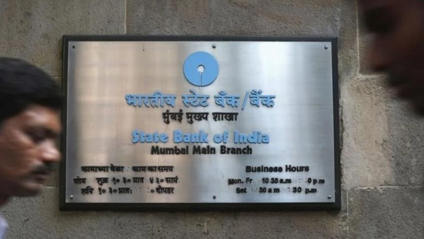 People walk in front of a signboard displayed at the head office of State Bank of India in Mumbai People walk in front of a signboard displayed at the head office of State Bank of India in Mumbai