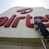 A worker cleans a logo of Bharti Airtel at its zonal office building in Chandigarh