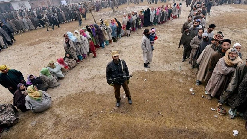A security person stands guard as people wait in queues in the Bandipora district of Jammu and Kashmir A security person stands guard as people wait in queues in the Bandipora district of Jammu and Kashmir