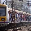 Commuters travel by a local train in Mumbai