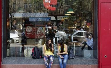 Big-name market debuts at odds with thin IPO pipeline Girls sit at the window of a Cafe Coffee Day outlet in Mumbai,