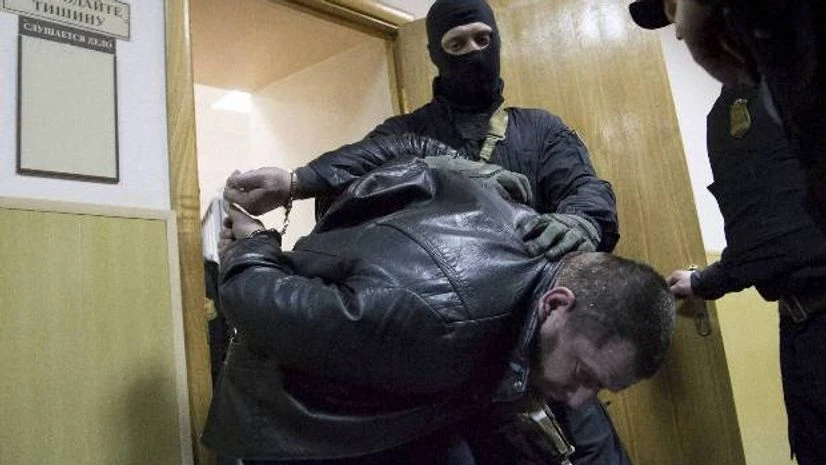 Police escort Tamerlan Eskerkhanov one of five suspects in the killing of Boris Nemtsov from a court room in Moscow