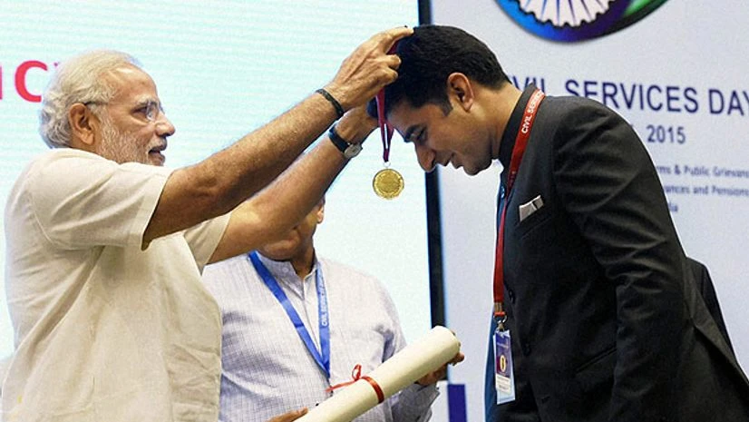 Prime Minister Narendra Modi presents an award to Shahid Iqbal Choudhary, an IAS officer and Deputy Commissioner of Kathua, for excellence in public administration, at the Civil Services Day function in New Delhi on April 21, 2015. - PTI Photo