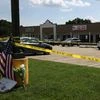 Police tape and a makeshift memorial frame the scene at an Armed Forces Career Center, where earlier in the day an active shooter opened fire