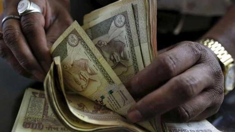 A money lender counts rupee currency notes at his shop in Ahmedabad A money lender counts rupee currency notes at his shop in Ahmedabad