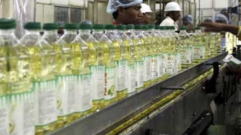 Employees fill plastic bottles with edible oil at an oil refinery plant of Adani Wilmar Ltd, a leading edible oil maker, in Mundra Employees fill plastic bottles with edible oil at an oil refinery plant of Adani Wilmar Ltd, a leading edible oil maker, in Mundra
