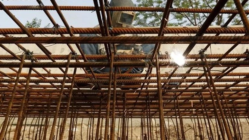 A worker welds iron rods to build a seawall along a river at the construction site of residential and commercial buildings in Ahmedabad A worker welds iron rods to build a seawall along a river at the construction site of residential and commercial buildings in Ahmedabad