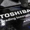 A man walks past a logo of Toshiba Corp at an electronics store in Tokyo