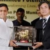 Uttar Pradesh Chief Minister Akhilesh Yadav is presented a memento by a representative of Toshiba during the Investors Conclave in Mumbai