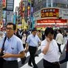 People cross a busy junction outside the nightlife district in Shinjuku in Tokyo