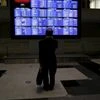 A man looks at an electronic board showing Japan's Nikkei average and related indices at the Tokyo Stock Exchange (TSE) in Tokyo