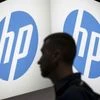An attendee at the Microsoft Ignite technology conference walks past the Hewlett-Packard (HP) logo in Chicago, Illinois