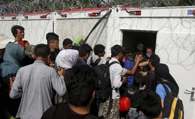 Record 218,000 migrants crossed Mediterranean in October: UN Hungarian police officers open a door to a container where migrants are registered as they enter Hungary, near Horgos, Serbia