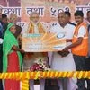 Prime Minister Narendra Modi presents micro-loan cards to beneficiaries while giving away e-rickshaws and pedal rickshaws to help impoverished families with sustainable livelihood under the government's financial inclusion programme, at a function in