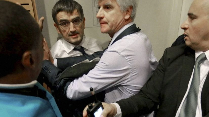 Air France director of Human Ressources, Xavier Broseta, center left, and Air France assistant director long-haul flight, Pierre Plissonnier, center right, are protected by Air France security guards during scuffles with union activists inside the Ai Air France director of Human Ressources, Xavier Broseta, center left, and Air France assistant director long-haul flight, Pierre Plissonnier, center right, are protected by Air France security guards during scuffles with union activists inside the Ai