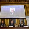 A picture of British economist Angus Deaton, winner of the 2015 economics Nobel Prize, is seen on a screen as Goran K. Hansson (C), permanent secretary for the Royal Swedish Academy of Sciences, and Tore Ellingsen (L), chairman of the prize committee