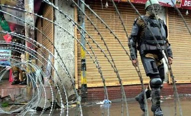 Tension in parts of Jammu after alleged desecration of temple A security personnel stands guard during a bandh in Kashmir