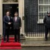 Chinese President Xi Jinping, center, and British Prime Minister David Cameron pose for photographs for the media before their meeting at 10 Downing Street, in London