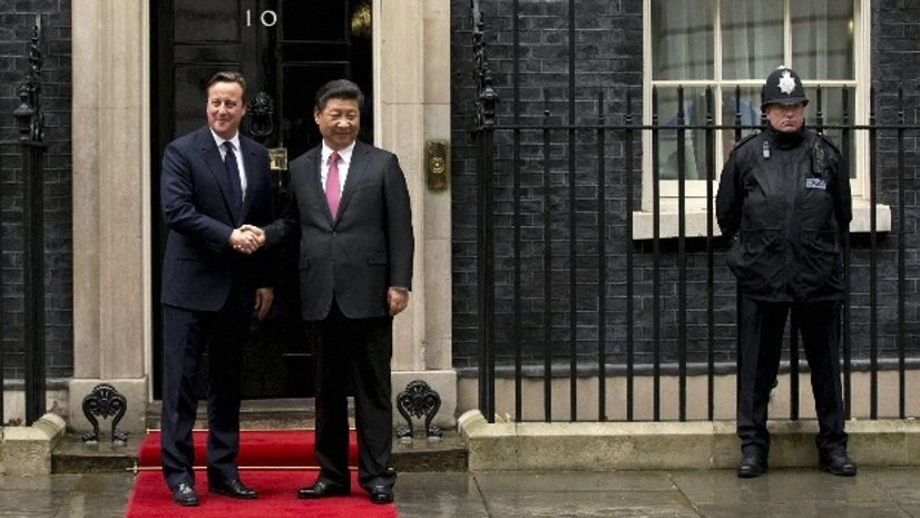 Chinese President Xi Jinping, center, and British Prime Minister David Cameron pose for photographs for the media before their meeting at 10 Downing Street, in London Chinese President Xi Jinping, center, and British Prime Minister David Cameron pose for photographs for the media before their meeting at 10 Downing Street, in London