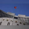 A Chinese national flag flutters outside the headquarters of the People's Bank of China, the Chinese central bank, in Beijing