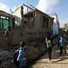 Afghan school boys walk to look a damaged house following a powerful earthquake that could be felt across South Asia, in Kabul, Afghanistan, Monday, Oct. 26, 2015.