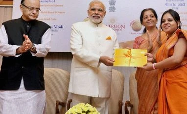 Gold deposits to get 2.25-2.5% returns Prime Minister Narendra Modi presenting Gold bond to a woman during the launch of Government Gold schemes, in New Delhi on Thursday. Union Finance Minister Arun Jaitley, Minister of State for Finance, Jayant Sinha and the Minister of State for Commer
