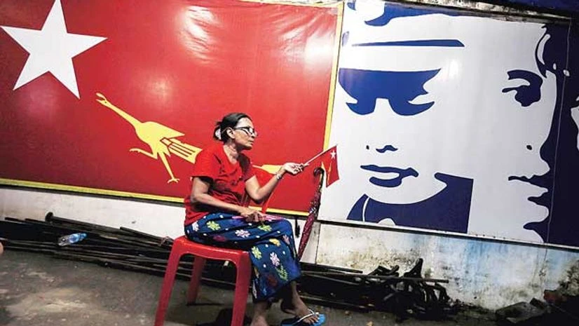 A supporter of Myanmar's pro-democracy figurehead Aung San Suu Kyi sits inside National League for Democracy headquarters in Yangon, Myanmar A supporter of Myanmar's pro-democracy figurehead Aung San Suu Kyi sits inside National League for Democracy headquarters in Yangon, Myanmar