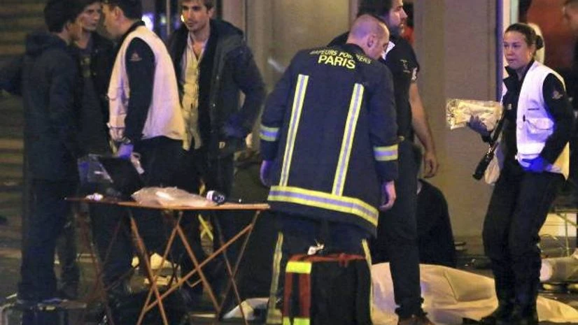 Rescue workers at the scene as victims lay on the pavement outside a Paris restaurant. Photo: AP/PTI Rescue workers at the scene as victims lay on the pavement outside a Paris restaurant.