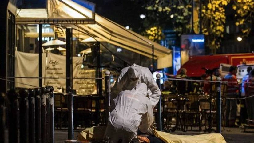 Police officers inspect the body of a victim of a shooting attack outside the Bataclan concert hall in Paris, France. Photo: AP/PTI Police officers inspect the body of a victim of a shooting attack outside the Bataclan concert hall in Paris, France.