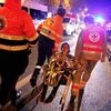 A person is being evacuated after a shooting, outside the Bataclan theater in Paris, France