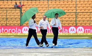 India-SA Bengaluru Test ends in draw as play is called off Umpires Ian Gould (C), Richard Kettleborough (R) and Fourth umpire Nandan (L) returns to pavilion after an inspection of the ground on the 4th day of the 2nd test match between India-South Africa at Chinnaswamy Stadium in Bengaluru. (File Photo: PTI)
