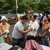 People rescued at waterlogged houses of Kotturpuram, receiving food packets while sheltering at a road following rains in Chennai