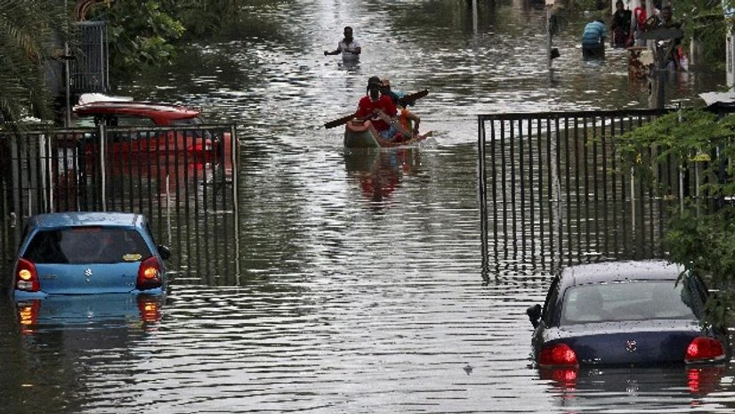 People travel on a boat as they move to safer places through a flooded road in Chennai People travel on a boat as they move to safer places through a flooded road in Chennai
