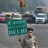 A civil defence volunteer holds a placard during the trial of the 'odd-even car scheme' at ITO in New Delhi