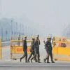 Security personnel walk at the Rajpath near India Gate in New Delhi