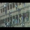 In this file video grab, friends and family of students taking the Bihar board exams climb walls to pass them chits.  (Photo: YouTube)