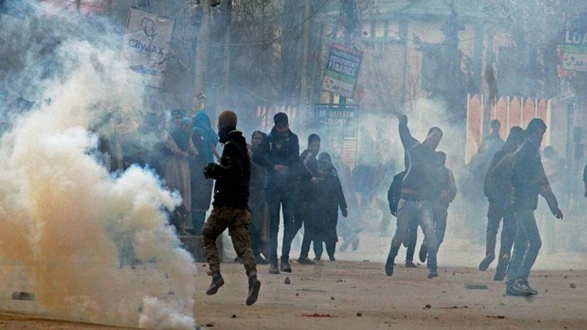 Unrest in Kashmir Angry youth throwing stones on police amid tear gas smoke fired by police to disperse them during clashes on Srinagar-International Airport Road at Peerbagh in Srinagar.