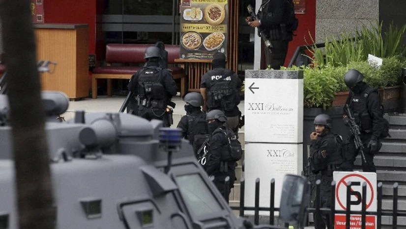 Police officers take their position outside a Pizza Hut restaurant next door to a Starbucks cafe which was attacked in Jakarta Police officers take their position outside a Pizza Hut restaurant next door to a Starbucks cafe which was attacked in Jakarta