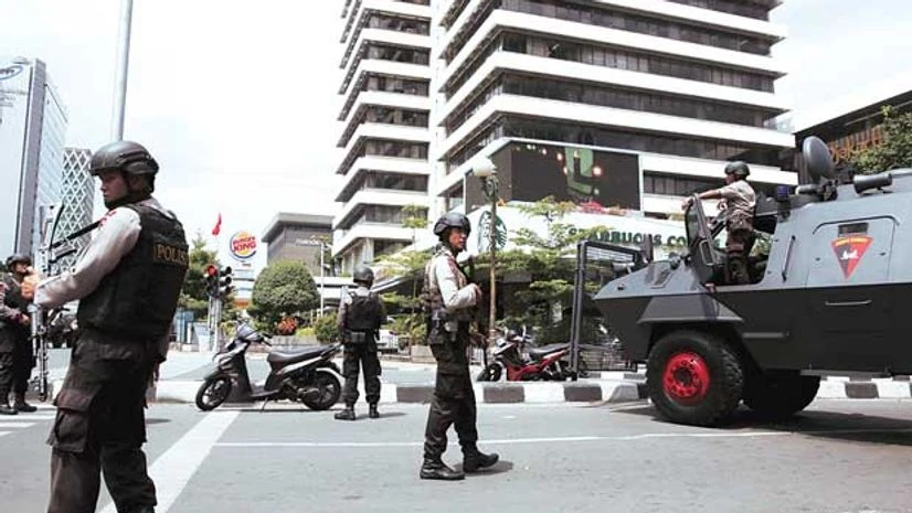 Indonesian policemen with weapons and an armoured vehicle guard in front of a Starbucks cafe at Thamrin business district in Jakarta on Thursday Indonesian policemen with weapons and an armoured vehicle guard in front of a Starbucks cafe at Thamrin business district in Jakarta on Thursday