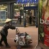 A woman pushes a cart in a retail area of Market Street in San Francisco, California