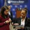 A job applicant (L) has her resume looked at during a U.S. Chamber of Commerce Foundation "Hiring Our Heroes" military job fair in Washington