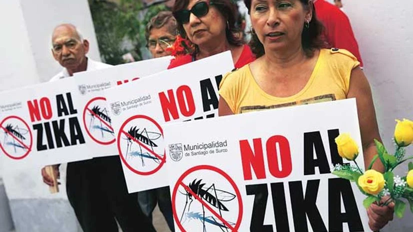 People hold signs against the Zika virus during a fumigation of the cemetery of Surco to prevent the virus and other mosquito-borne diseases in Lima, Peru People hold signs against the Zika virus during a fumigation of the cemetery of Surco to prevent the virus and other mosquito-borne diseases in Lima, Peru