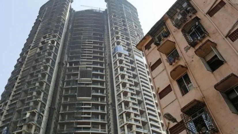 An under construction high-rise residential tower is pictured behind an old residential building in Mumbai An under construction high-rise residential tower is pictured behind an old residential building in Mumbai