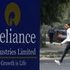 A man walks past a Reliance Industries Limited sign board installed on a road divider in Gandhinagar. Photo: Reuters