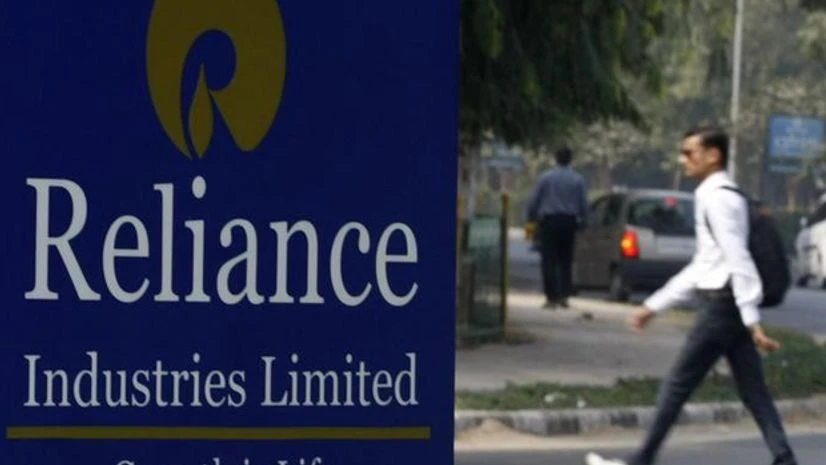 A man walks past a Reliance Industries Limited sign board installed on a road divider in Gandhinagar. Photo: Reuters A man walks past a Reliance Industries Limited sign board installed on a road divider in Gandhinagar. Photo: Reuters
